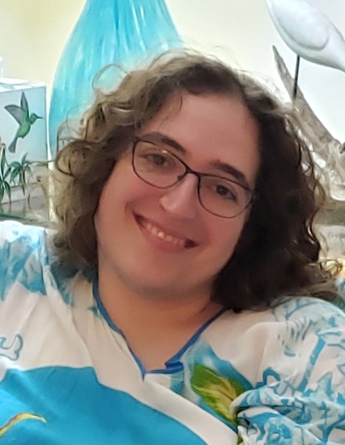 A photo of a woman with curly hair and glasses.